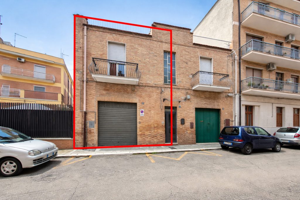 Facciata dell’immobile in Via Leone Ferrone a Lucera con ampio garage al piano terra e spazi esterni privati.